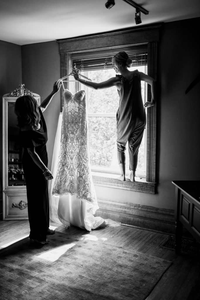 bride holding dress in window